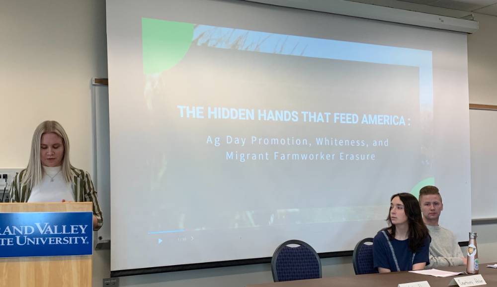 Student presenting on migrant agricultural laborers as "the hidden hands that feed America."